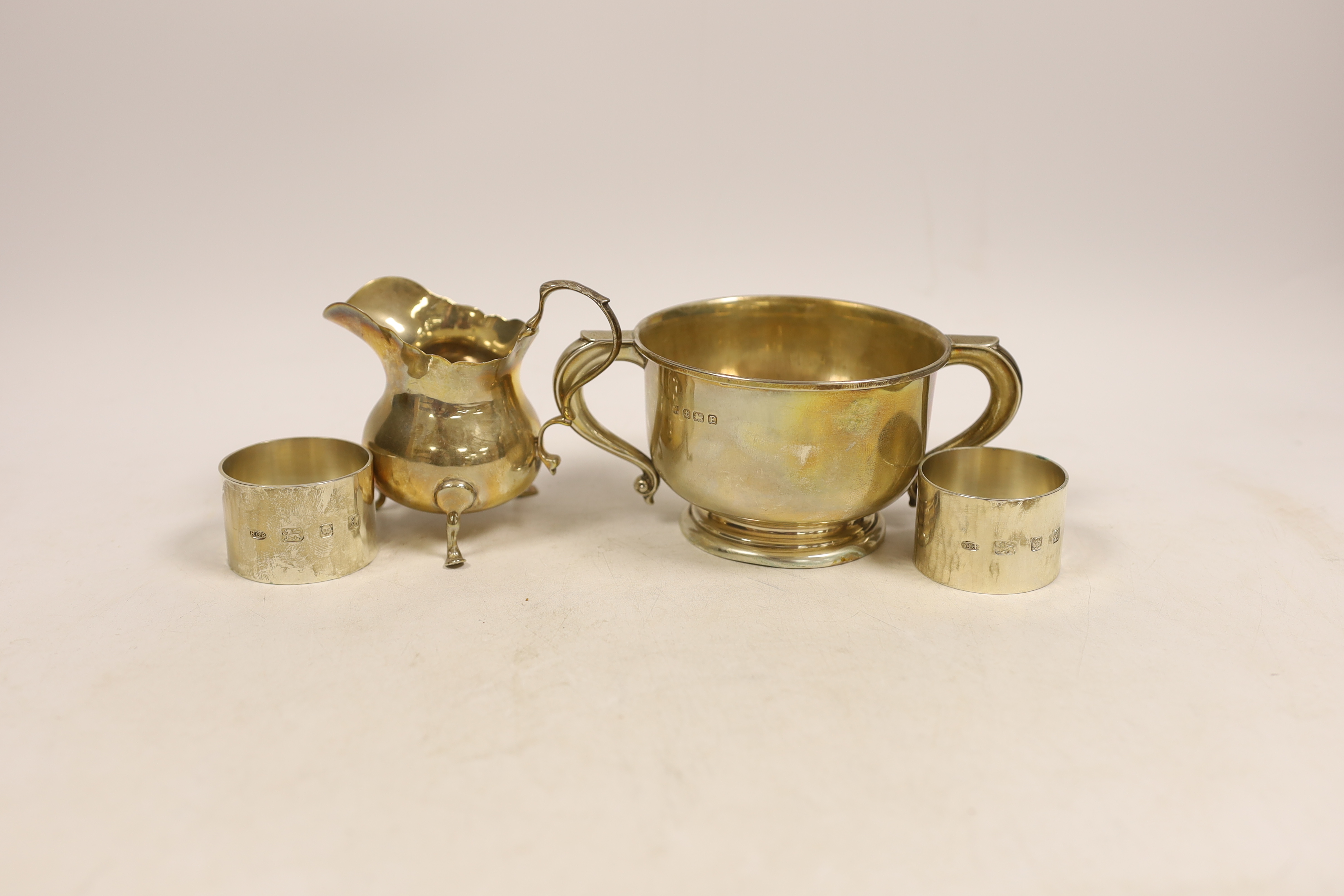 A silver bellied cream jug, a circular silver two handled bowl and a pair of modern silver napkin rings by Rodney Clive Petitt, 10.2oz.